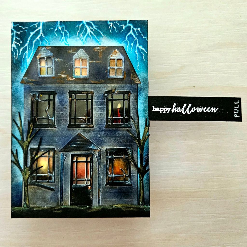 Haunted house card for Halloween with interactive slide tab of a lady ghost behind the windows
