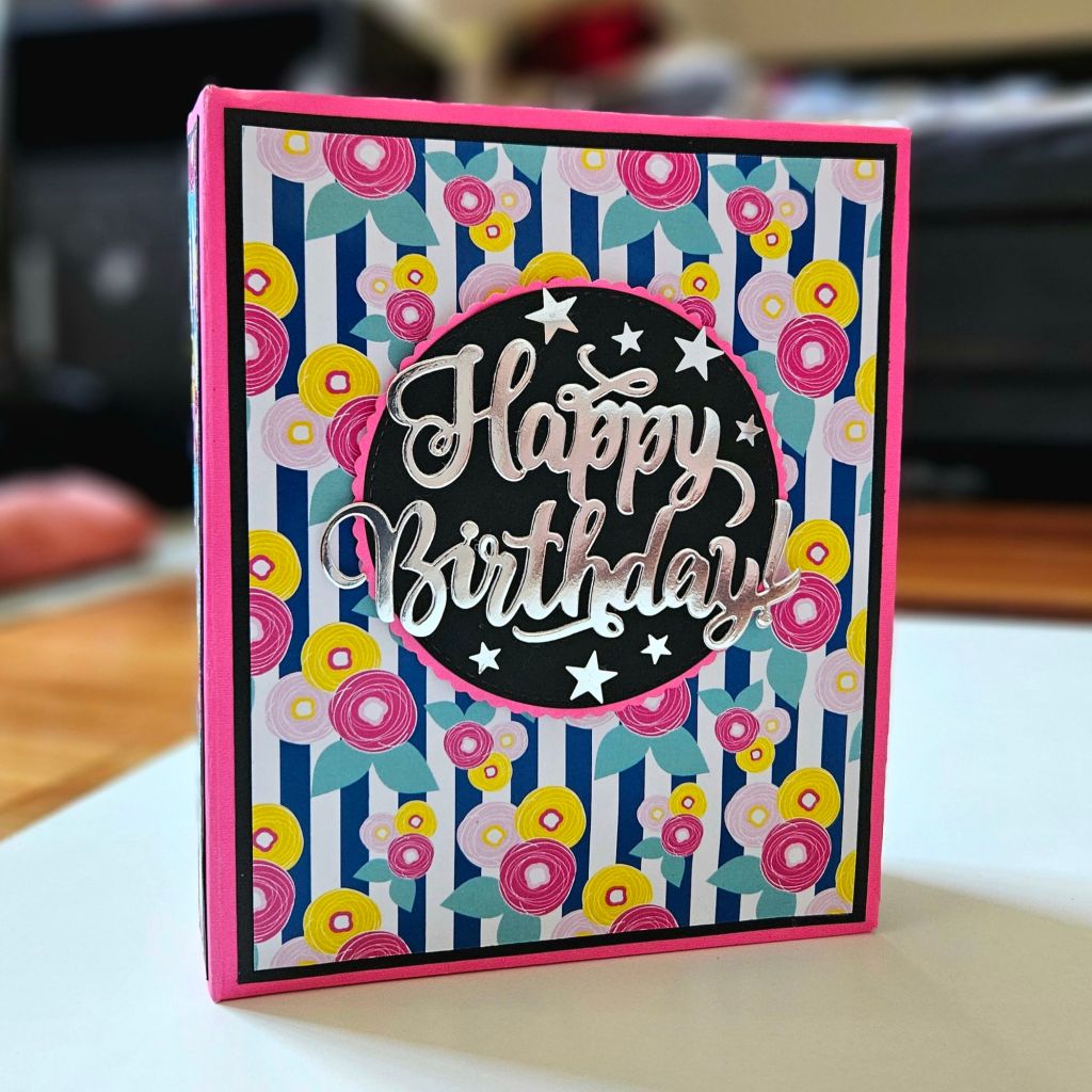 Handmade scrapbook celebrating a birthday girl with vibrant pink, blue, and yellow accents