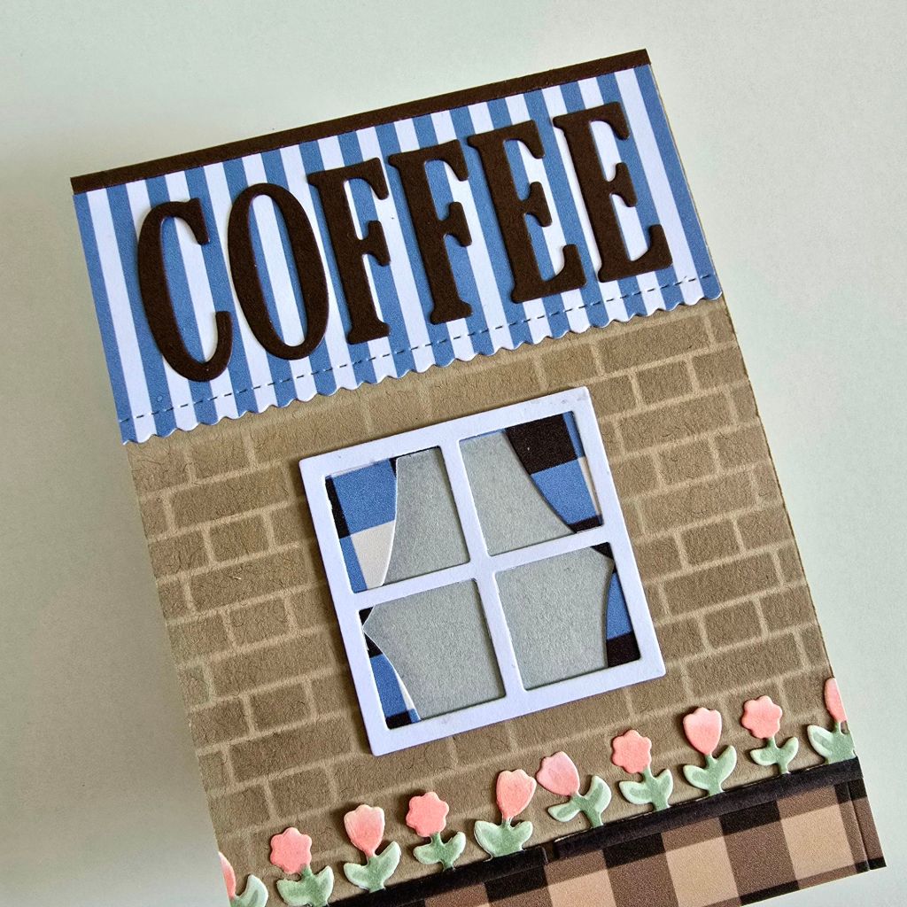 Beautifully crafted coffee-themed pop-up card in brown and blue hues. The cover showcases a cozy café storefront, and inside, a 3D couple sits together, sharing a warm cup of coffee.