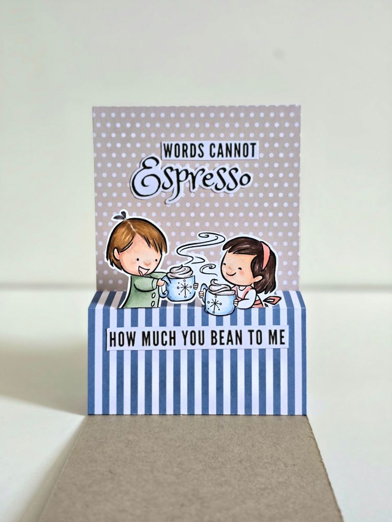 A handmade coffee-themed greeting card with a brown and blue color scheme. The front features a charming coffee shop illustration, while the inside reveals a delightful pop-up of a couple enjoying coffee together.